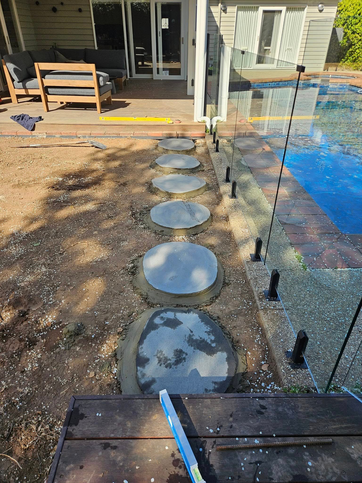 Round natural stone stepping stones installed beside the adjoining pool area.