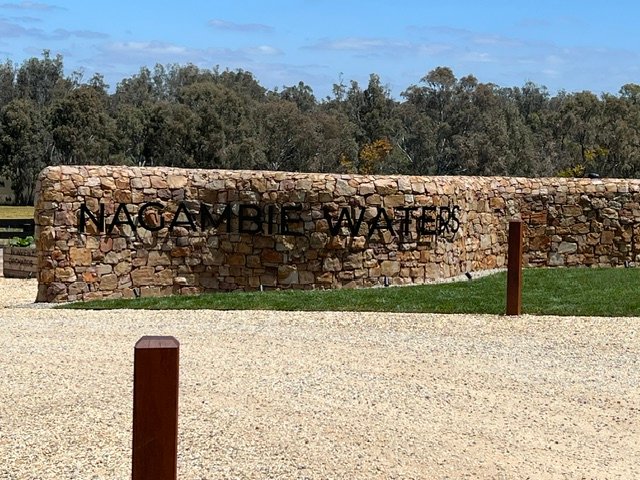 Completed entrance signage framed by natural stone, turf and the rural Nagambie landscape.