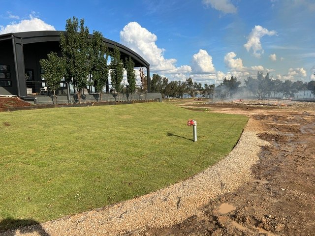 Fresh turf creates a green transition between the building and the wider site.