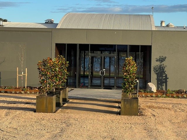 A practical and welcoming entrance finished with planters, planting and gravel.