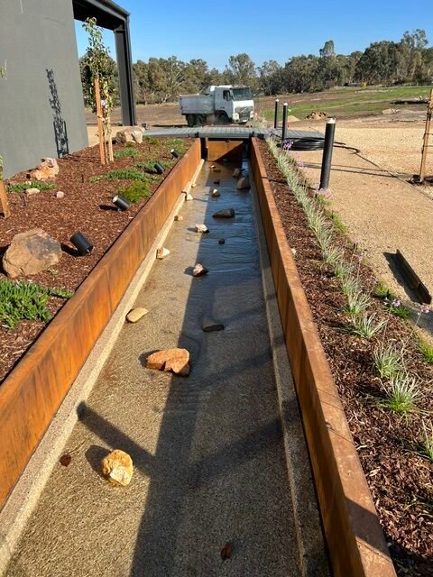 The completed linear water rill creates a strong focal line through the landscape.