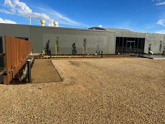 A clean and durable gravel finish connects the building with the surrounding landscape.